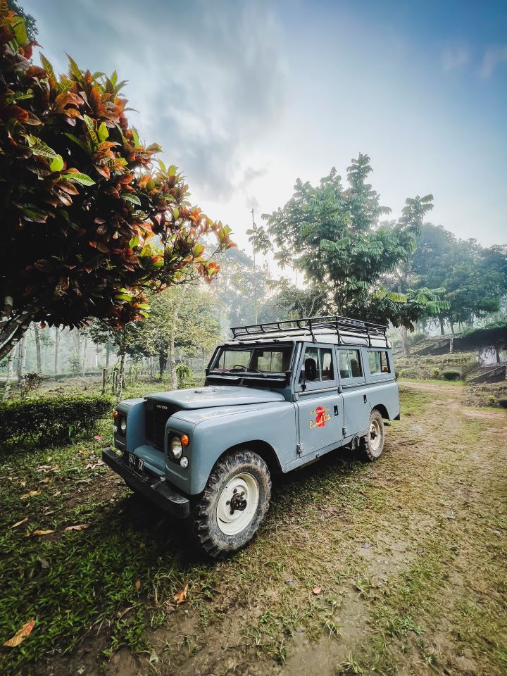 ruta por indonesia jeep 4x4 de color azul en el bosque aparcado